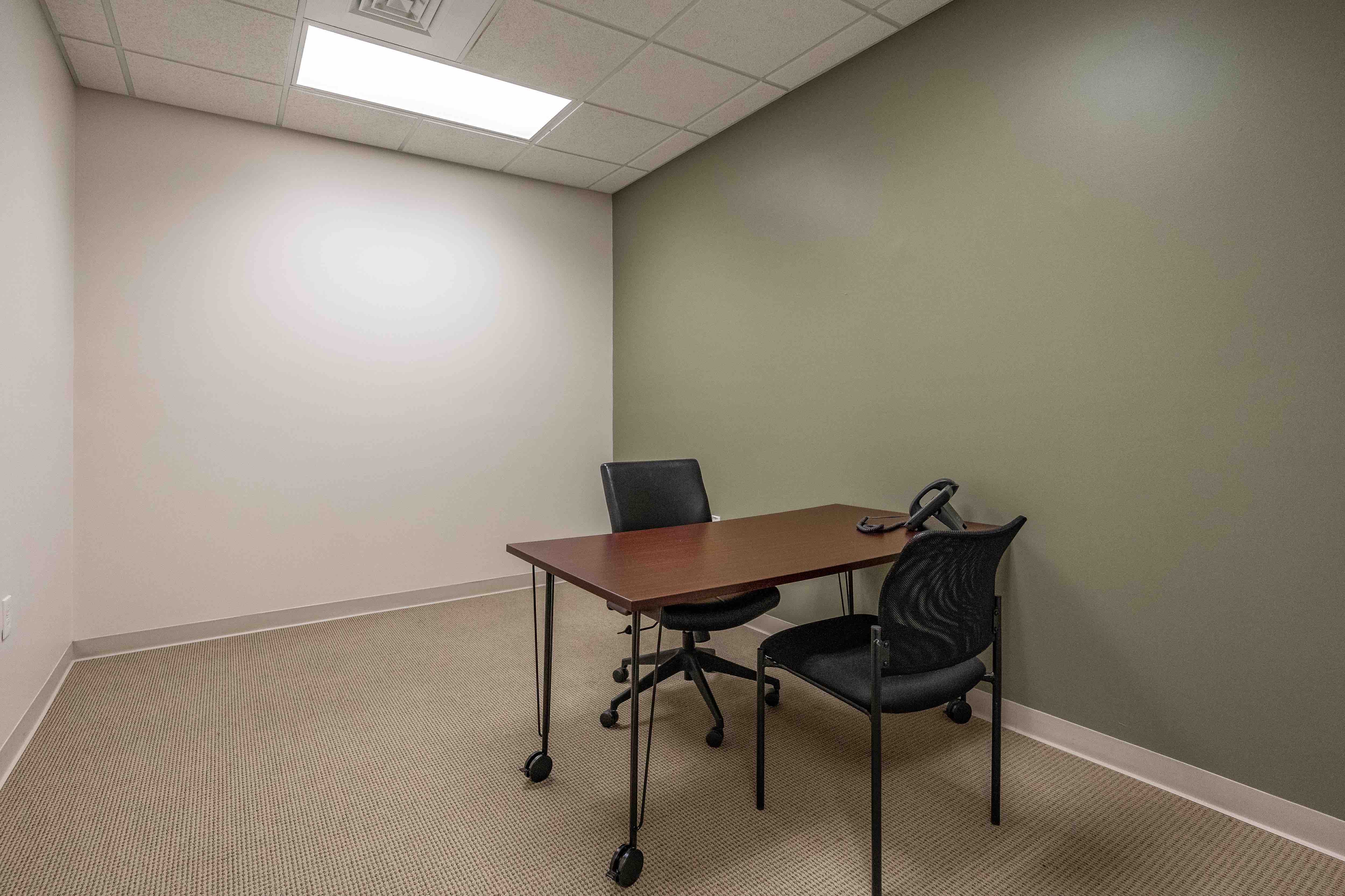 Private day office with desk and chairs